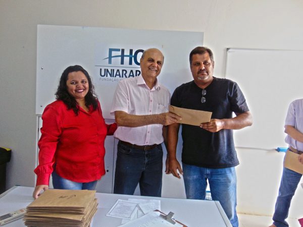 Aloísio recebendo das mãos do Prefeito Salim Curi e da Secretária Municipal de Educação e Cultura